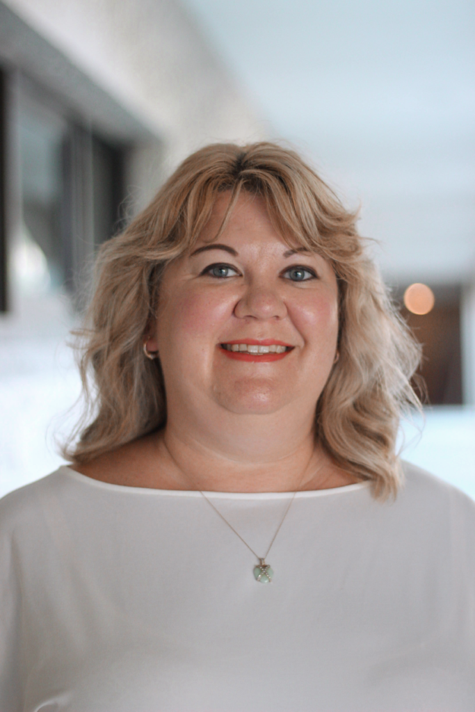 KimberlyBioPic (1) Empowered female farmer smiling, promoting agricultural training and sustainable farming practices.